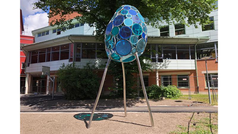 Ett ägg på tre ben, som består av cirklar i blått glas