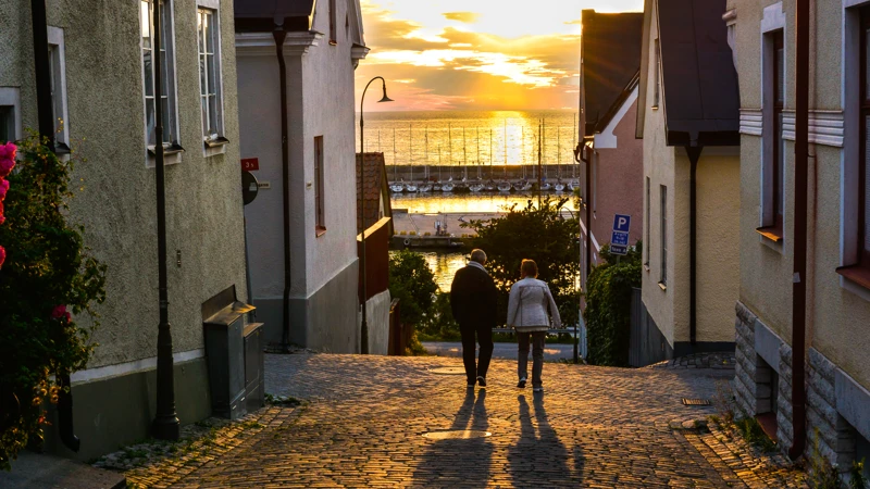 Några personer som går längs en kullerstensväg.
