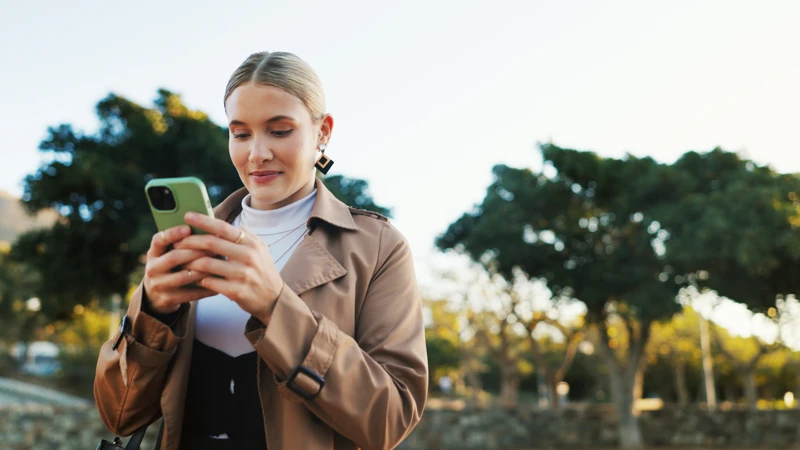 En kvinna tittar på sin mobiltelefon.