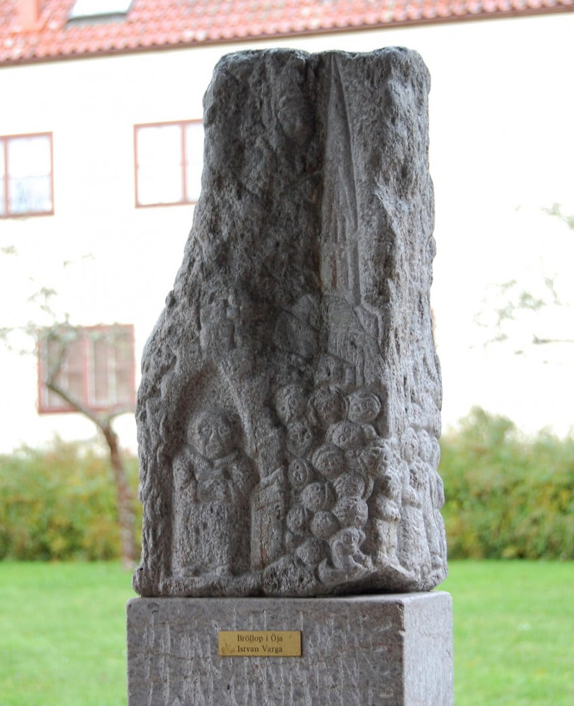 En stenskulptur står framför ett hus