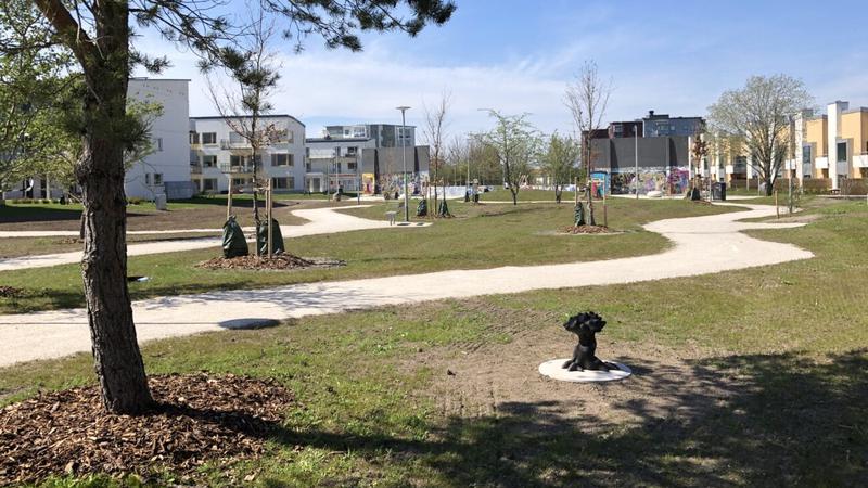 Skulpturen i sin miljö med gräs och hus längre bort