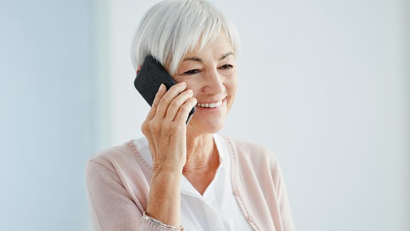 Äldre kvinna talar i telefon.