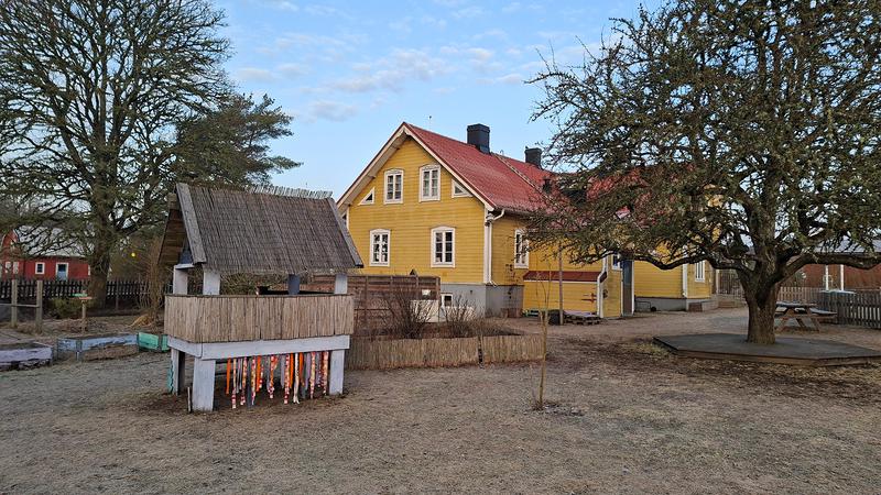 Ett litet gult hus med rött tak.