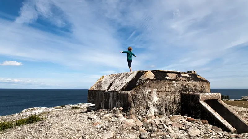 Barn med utsträckta armar på en bunker