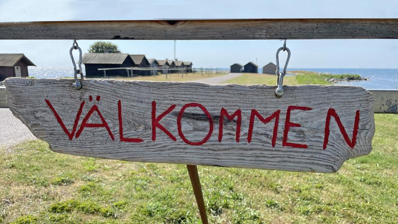 Skylt med Välkommen