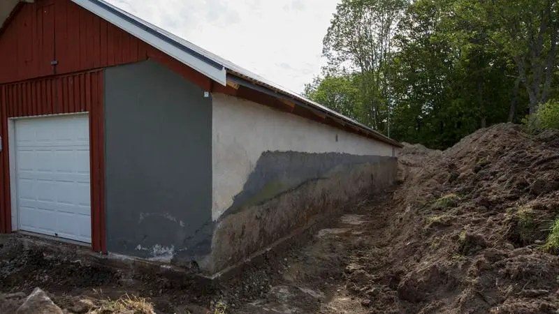 En röd och vit byggnad med en stor jordhög framför sig