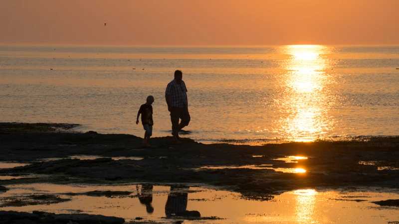 två personer går vid havet