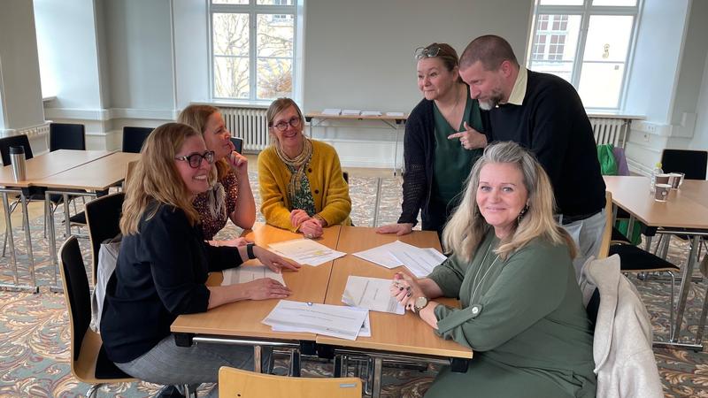 En grupp glada människor runt ett bord