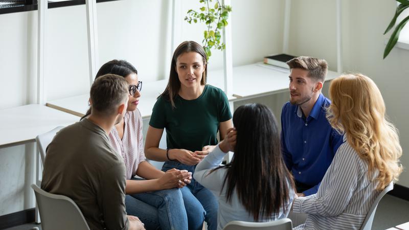 Personer sitter i en ring och diskuterar