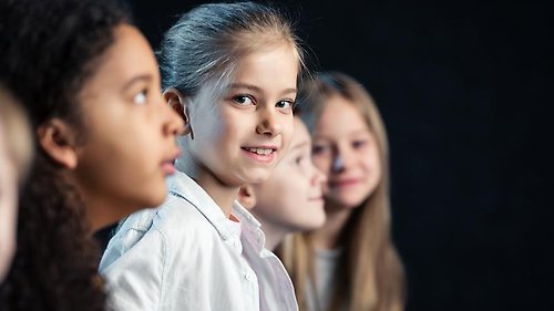 Fyra barn sitter på rad.