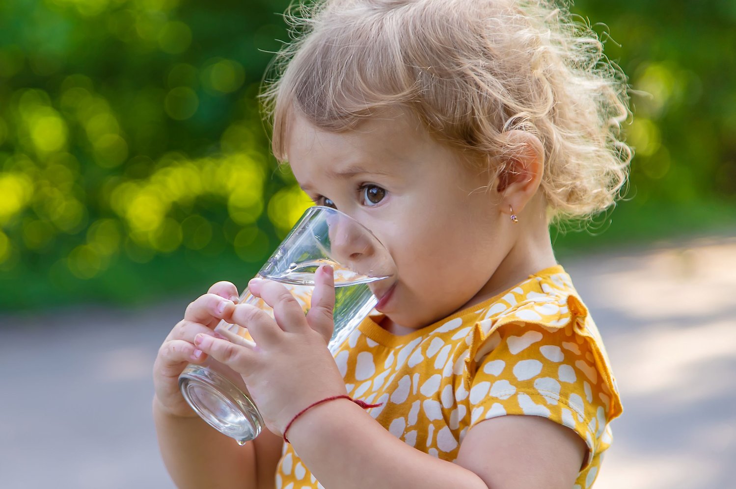 Barn dricker vatten ur ett glas