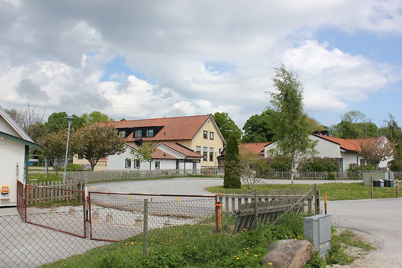 Insidan av skolgården med flera gula och vita byggnader.