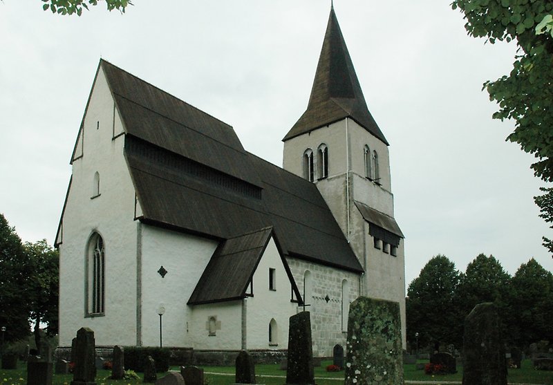 En stor vit stenkyrka med ett svart tak.