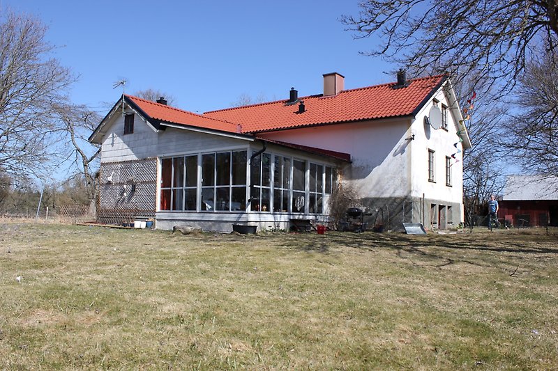Ett vitt hus med tillbyggd veranda