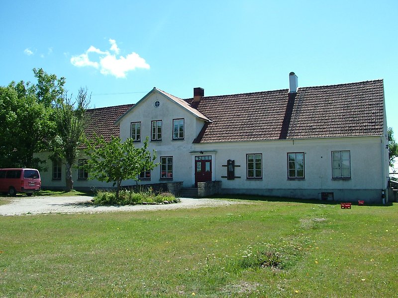 En vit envåningsbyggnad med ett rött tegeltak.