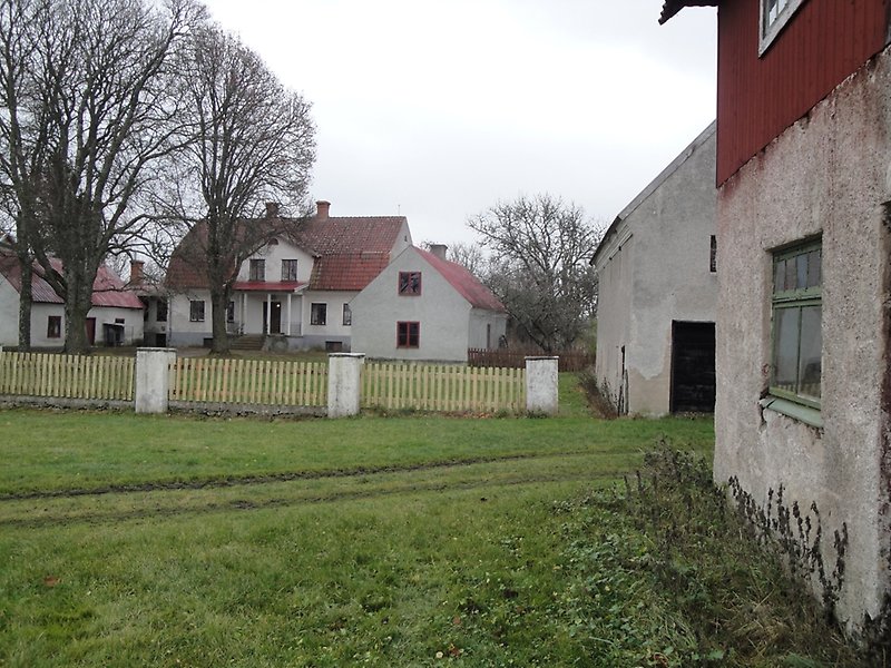 Flertal byggnader med röda tak och gult staket.
