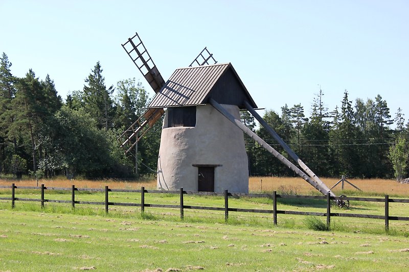 Kvarn mitt på gräsplan som är i sin tur omringad av skog