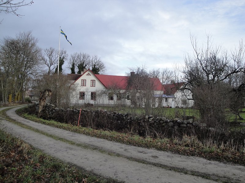 Tvåvånings villa med rött tak placerad jäms med vägen