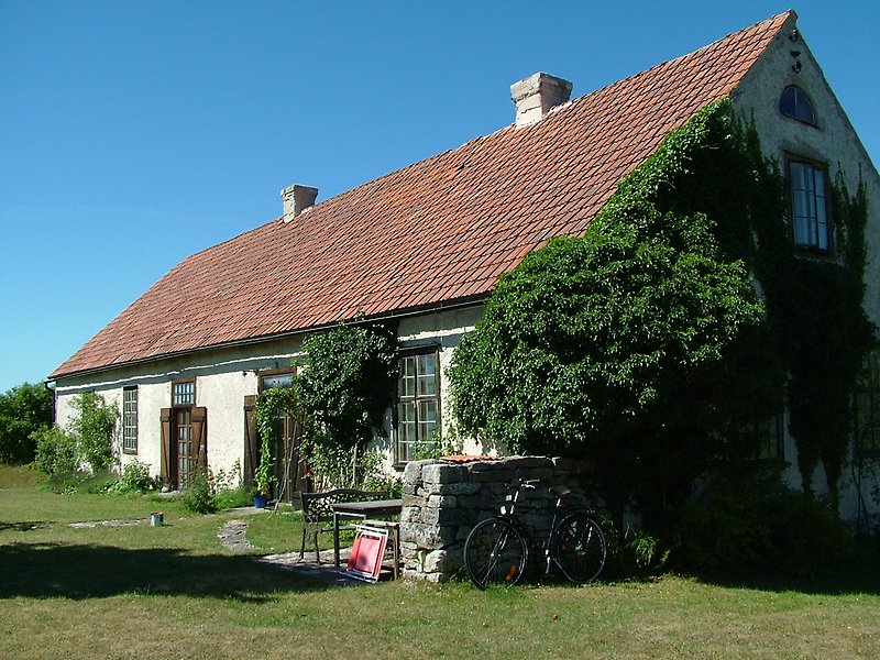 Ett vitt hus med två skorstenar och ett rött tak.