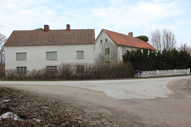 Två vita tvåvånings hus bredvid vägen.