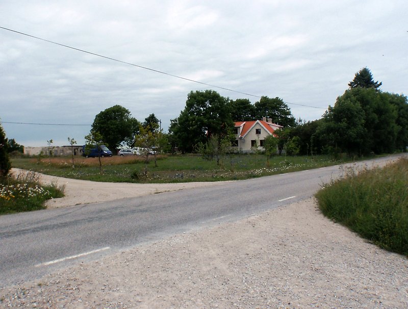 En korsning där asfalt övergår till en grusväg.