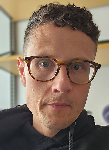 En medelålders man med kort hår och glasögon