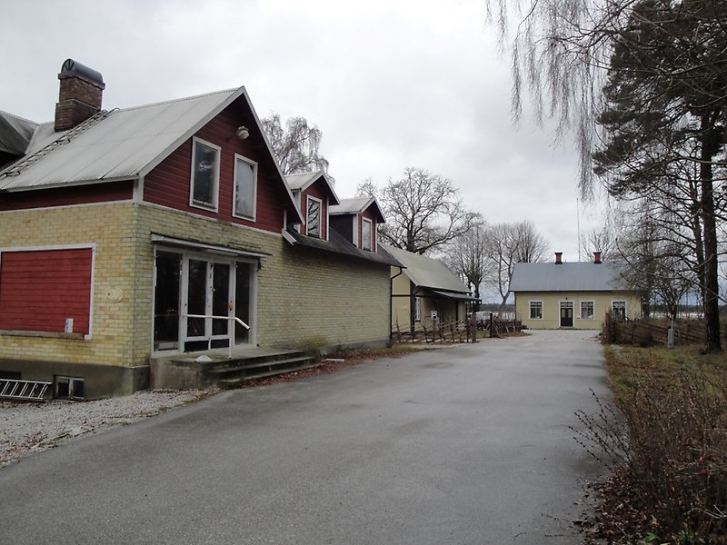 Flera byggnader av ljusgul färg och vita ytterdörrar.