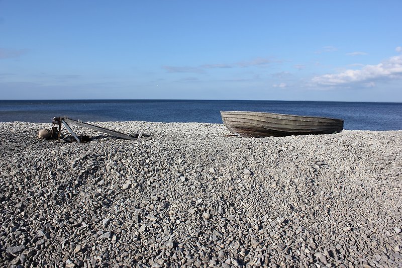 En stenig strand med en vacker utsikt över havet.