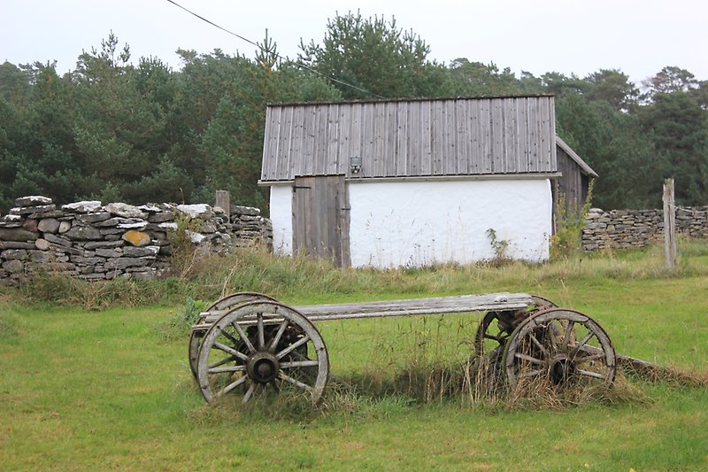 En liten stenbod med trätak och vita väggar.