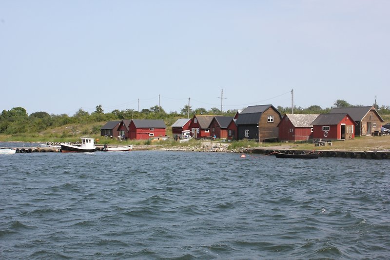 En utsikt över en liten fiskehamn med tiotals små fiskebodar.